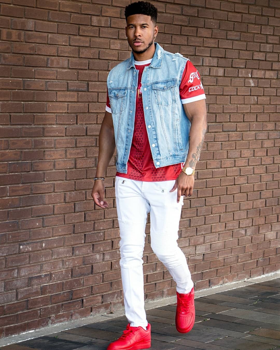 A gaming commentator at a desk with headphones, speaking into a microphone with a monitor in view