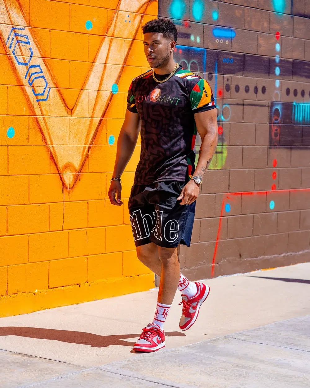 A gaming commentator at a desk with headphones, speaking into a microphone with a monitor in view