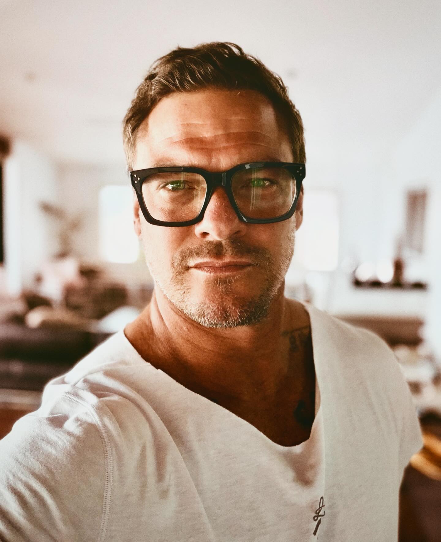 Alan Ritchson standing in a doorway, broad-shouldered and towering, conveying the imposing presence of Jack Reacher