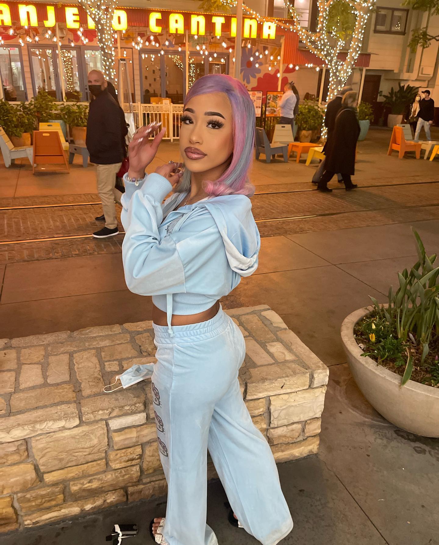 Aya Tanjali smiling and performing a short dance move in a casual home setting, emphasizing her expressive style and playful personality