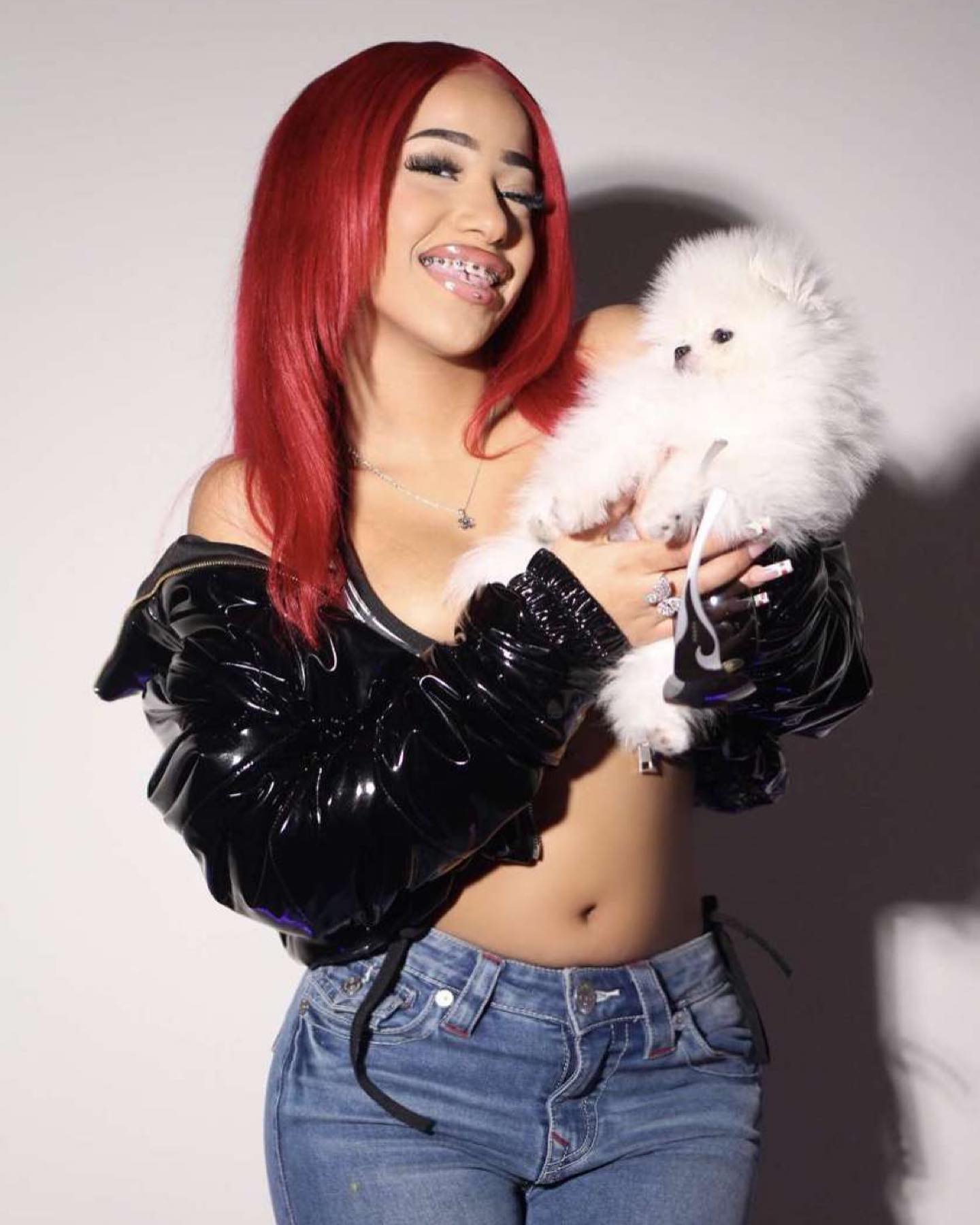 Aya Tanjali smiling and performing a short dance move in a casual home setting, emphasizing her expressive style and playful personality