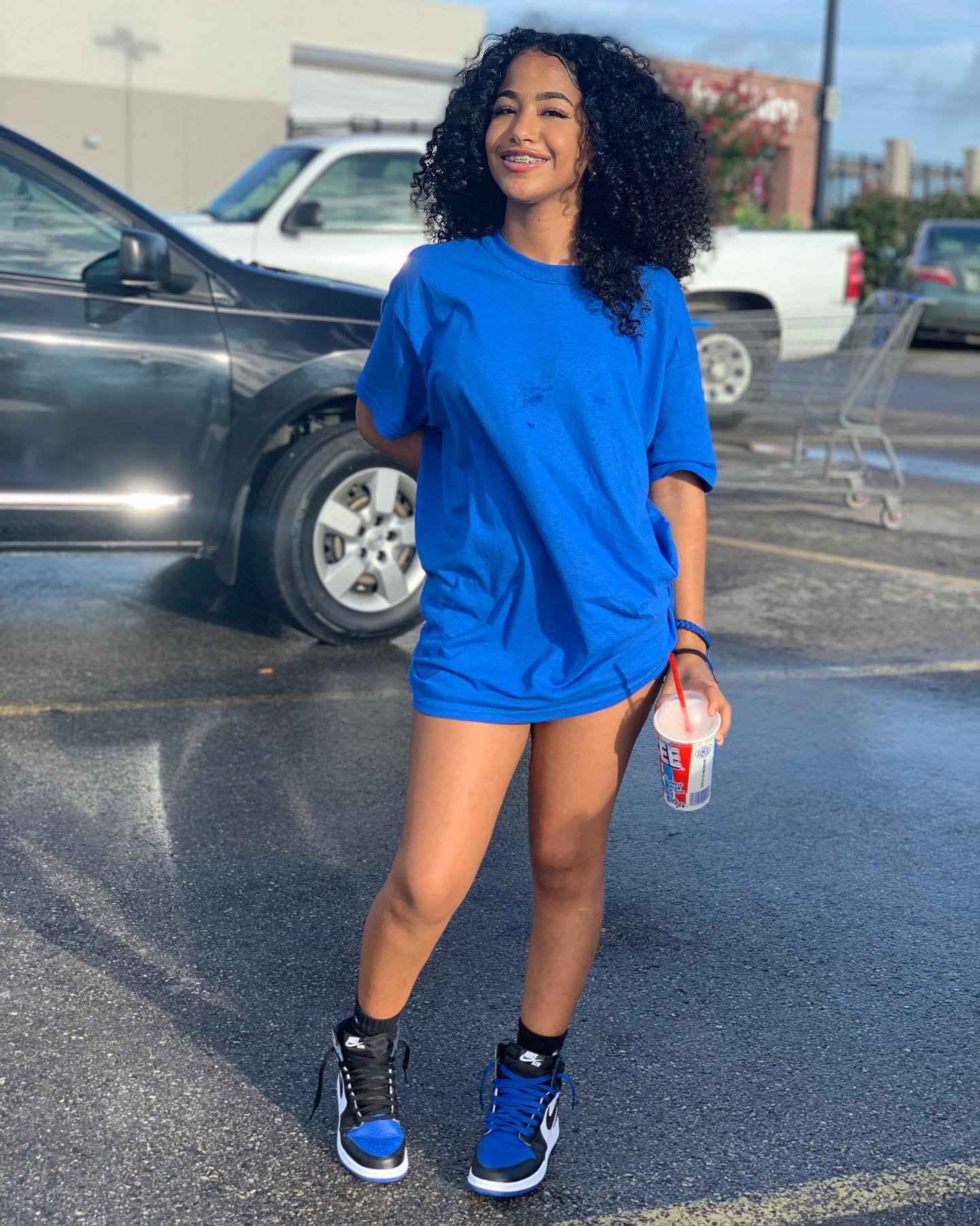 Aya Tanjali smiling and performing a short dance move in a casual home setting, emphasizing her expressive style and playful personality