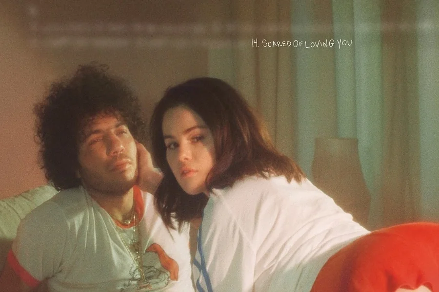 Benny Blanco and Selena Gomez standing together on a red carpet, appearing close in height with her in heels