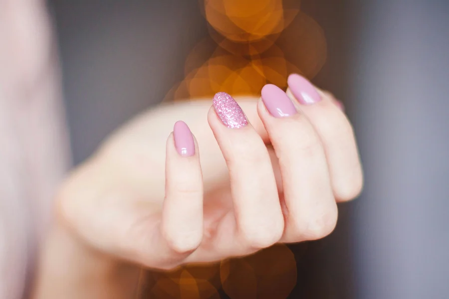 Close up of hands with a soft ombre manicure showing a gentle gradient from a light base to a deeper tip
