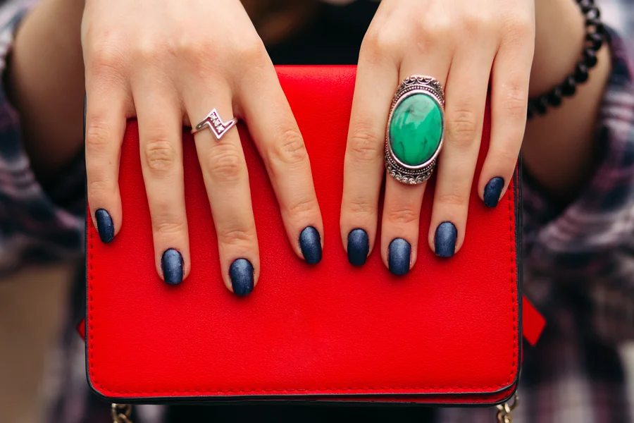 Close up of hands with modern French manicure featuring colored tips and clean neutral bases