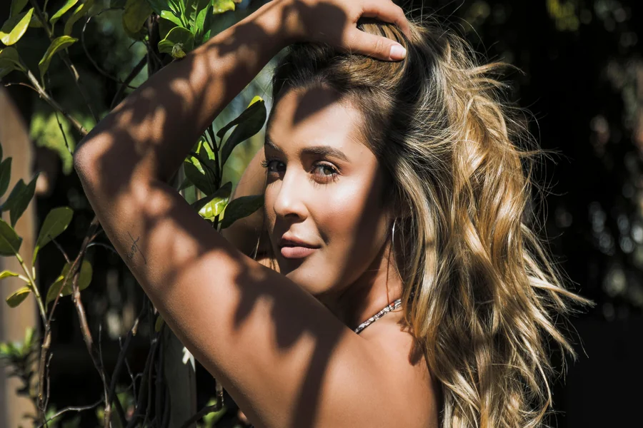 Close up of soft beige blonde hair with subtle highlights that look natural and glossy, styled in loose waves.