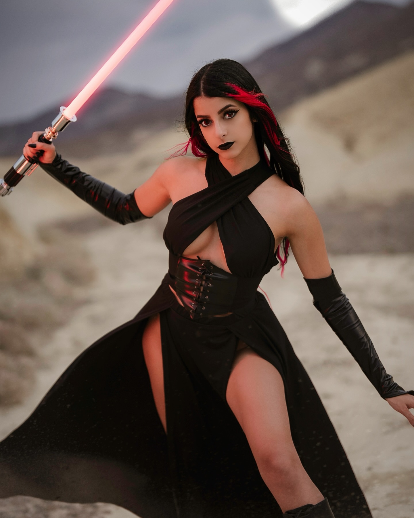 Cosplay creator in a glossy, colorful outfit striking a playful pose under studio lighting