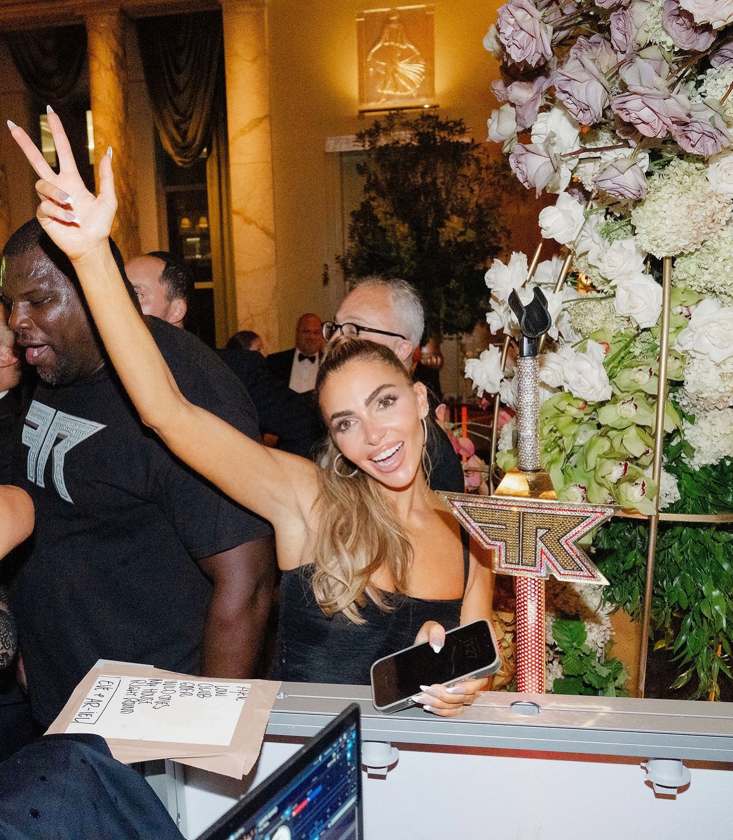 Eleonora Srugo speaking with clients in a modern Manhattan apartment, reflecting her real estate expertise and polished public presence
