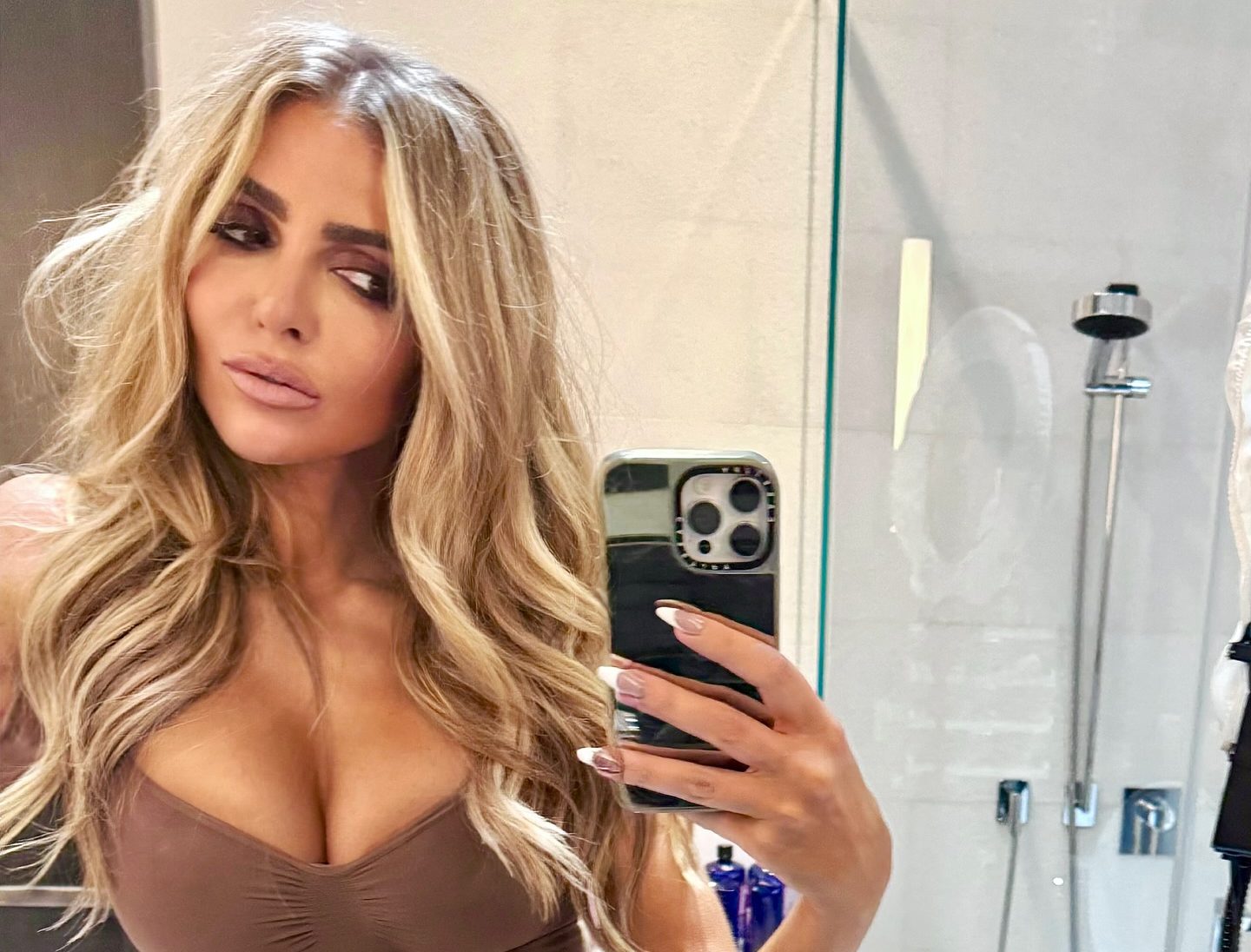 Eleonora Srugo speaking with clients in a modern Manhattan apartment, reflecting her real estate expertise and polished public presence