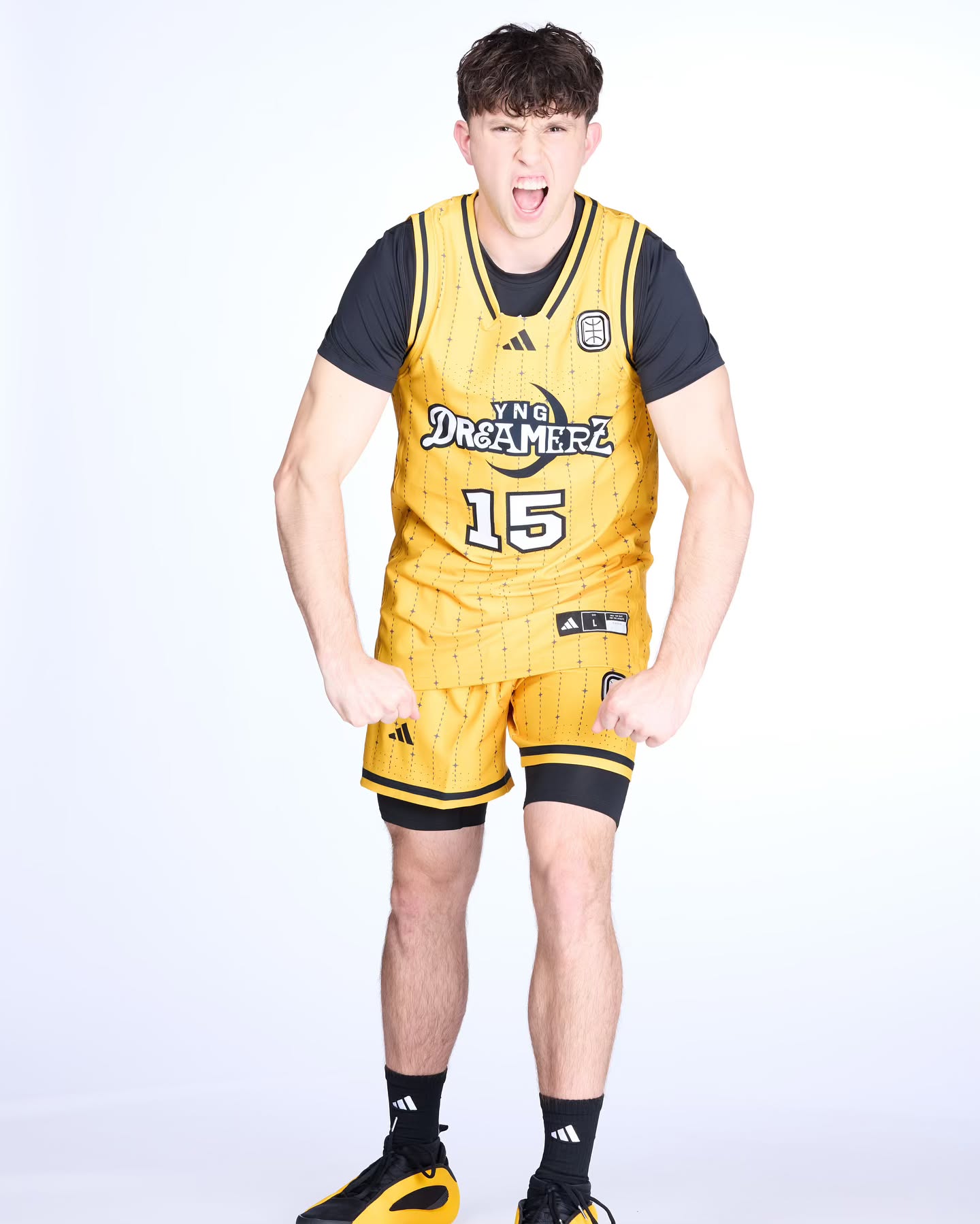 Eli Ellis dribbling a basketball on an indoor court, focused and in motion with teammates in the background