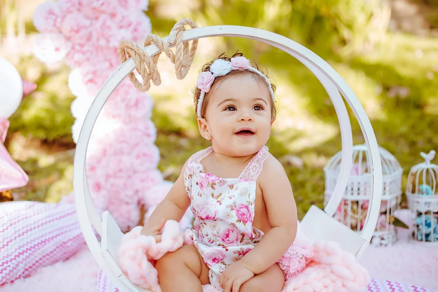 Margot Robbie in a pink power suit with sharp shoulders, styled to echo classic Barbie imagery on a red carpet.