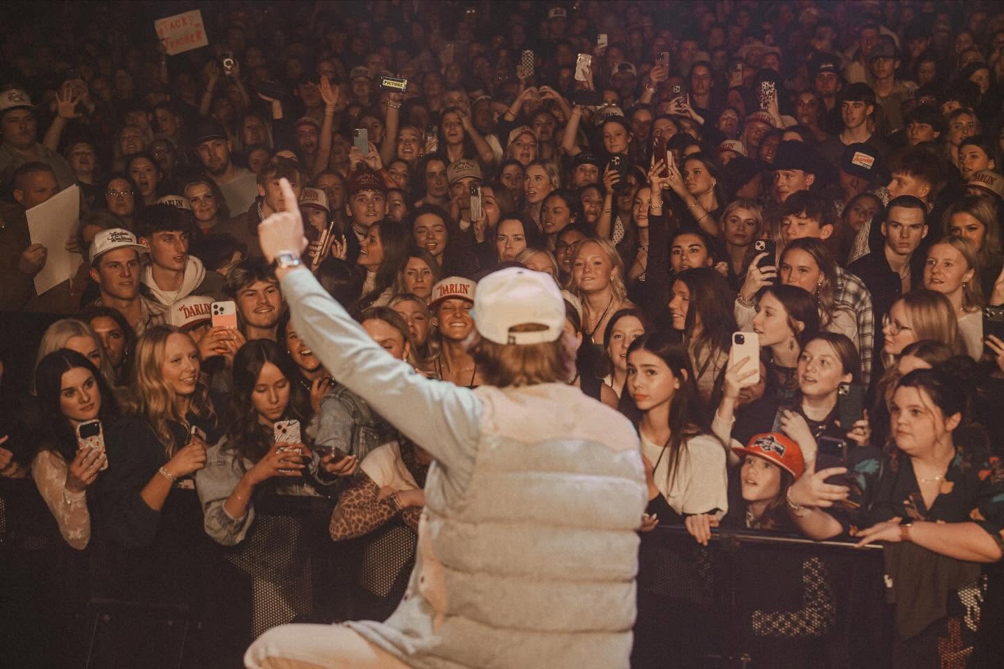 Hudson Westbrook performing on stage with a guitar under warm Texas lights, reflecting the storytelling heart of country music
