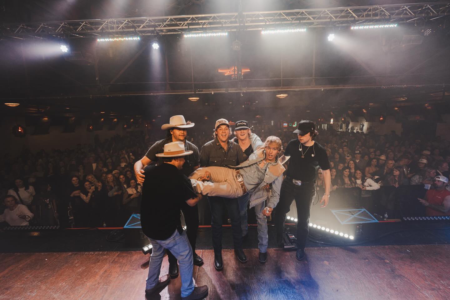 Hudson Westbrook performing on stage with a guitar under warm Texas lights, reflecting the storytelling heart of country music