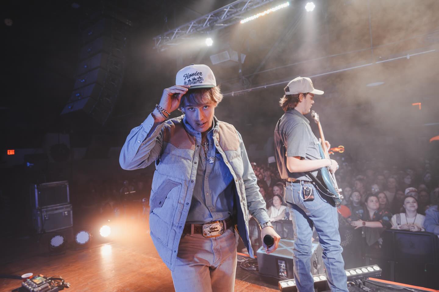 Hudson Westbrook performing on stage with a guitar under warm Texas lights, reflecting the storytelling heart of country music
