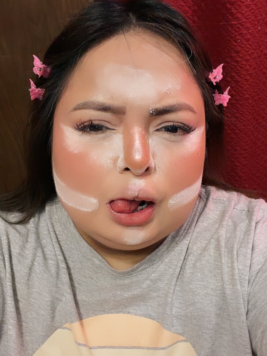 Jasmine Orlando, known as Shawty Bae, recording a short-form reaction video at home with an expressive look.