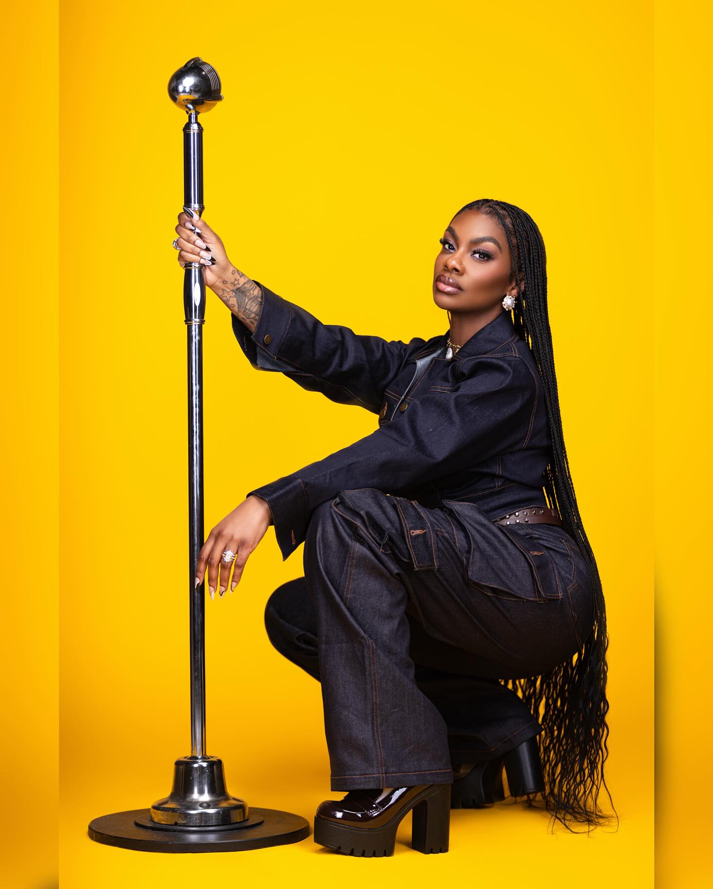 Jess Hilarious performing on stage, delivering a high energy set with expressive gestures.