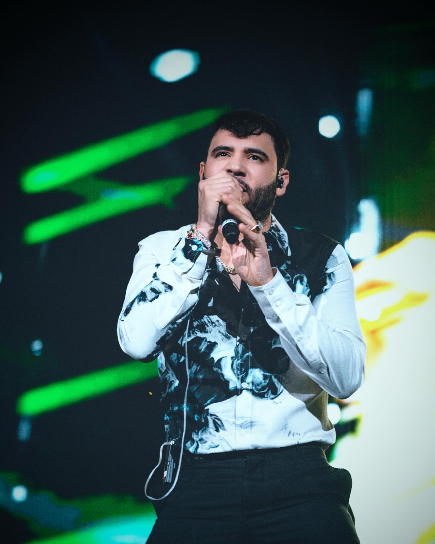 José Darey Castro performing onstage with an accordion, spotlighted against a backdrop that reflects Sonoran norteño heritage