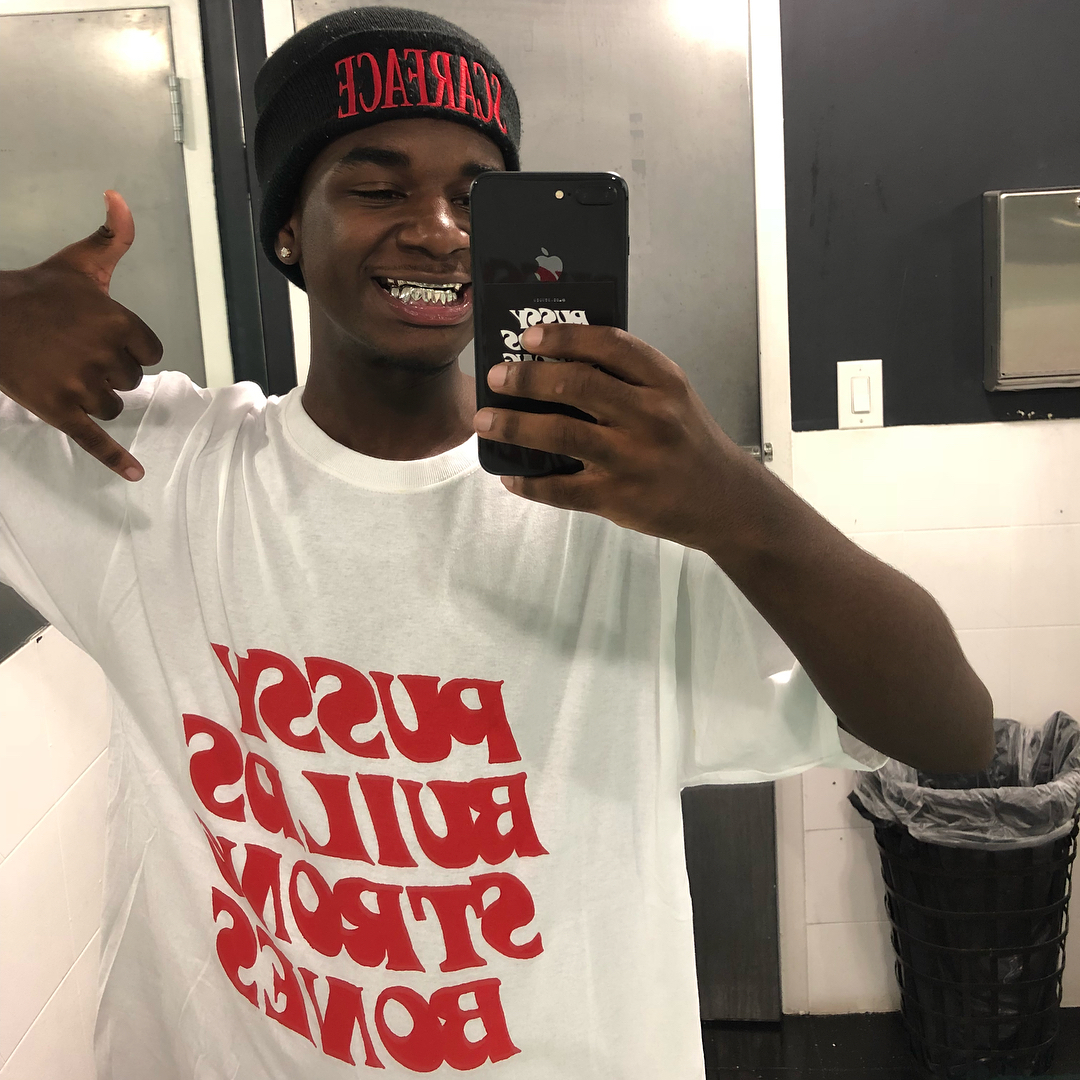 Ken Carson performing on stage under dark, futuristic lighting with an energized crowd.