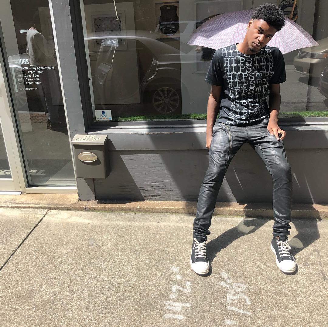 Ken Carson performing on stage under dark, futuristic lighting with an energized crowd.