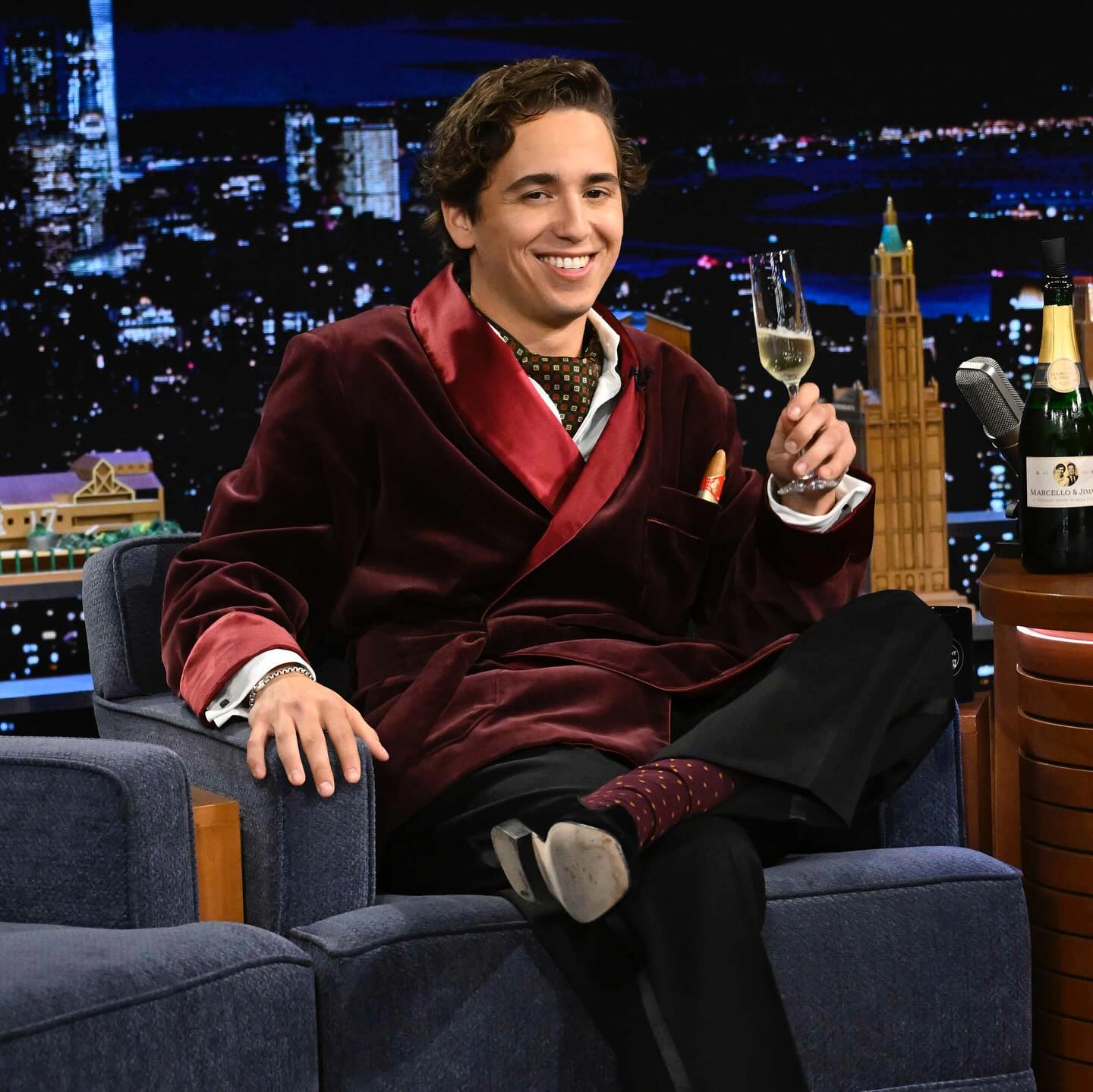 Marcello Hernandez performing a high-energy sketch on stage, highlighting his expressive movement and confident presence.