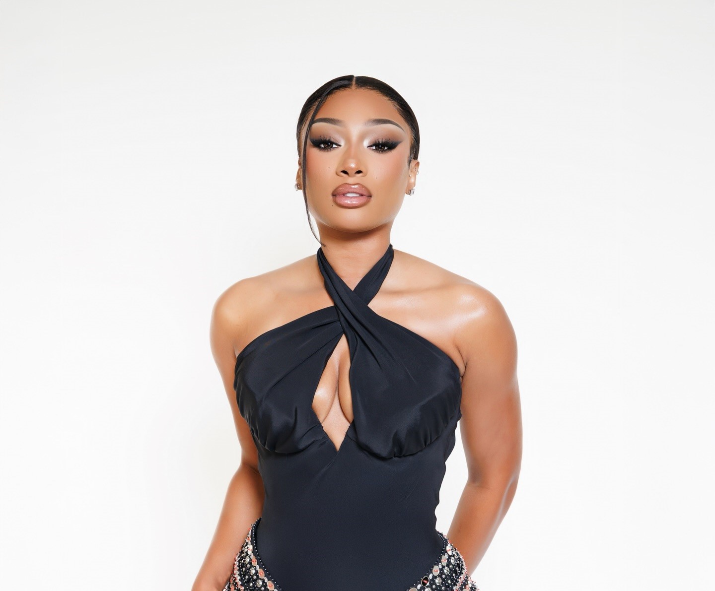 Megan Thee Stallion standing tall on stage in high heels, commanding the spotlight with confident posture.