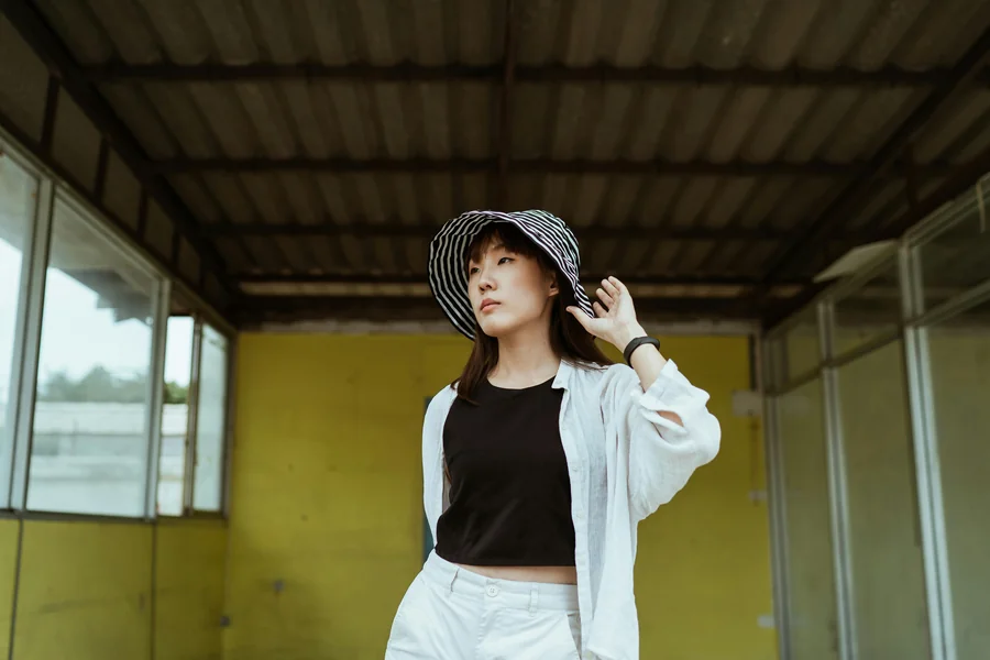 Person wearing a monochrome outfit that mixes textures, including a wool coat, knit sweater, and tailored trousers in the same color family