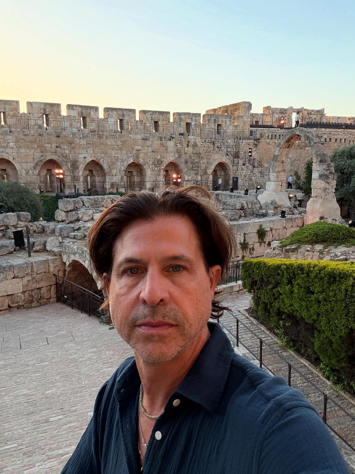 Rodger Berman at a fashion media event, dressed in a tailored suit, speaking with confidence in a professional setting