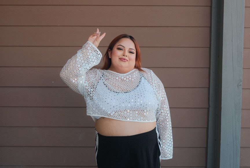 Jasmine Orlando, known as Shawty Bae, recording a short-form reaction video at home with an expressive look.
