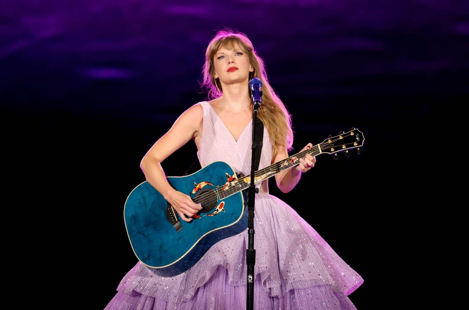 Taylor Swift performing on stage, conveying a reflective and expressive mood