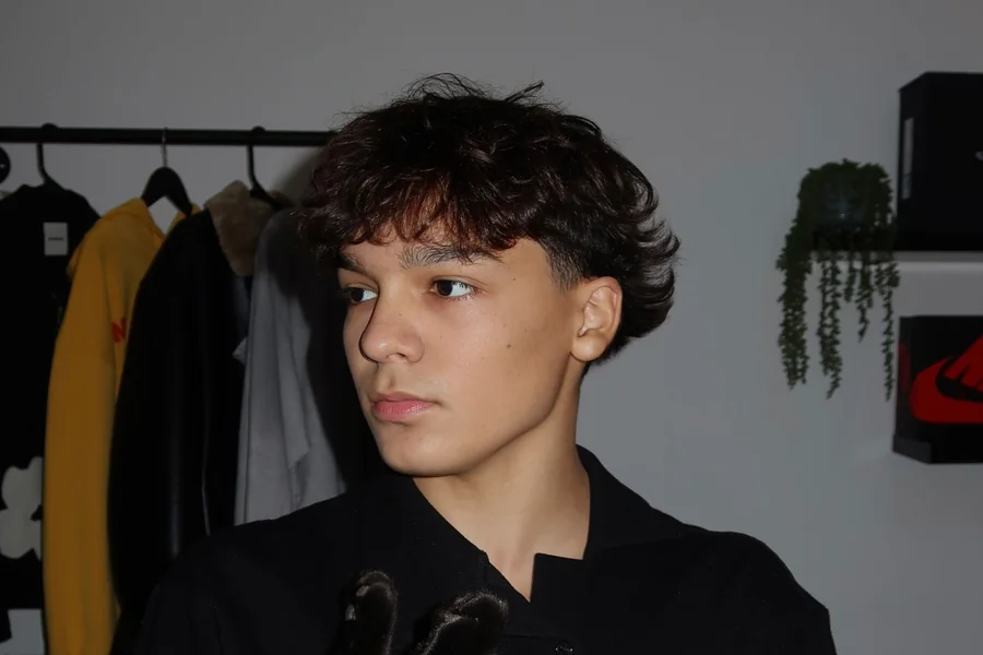 Trey Makai performing a contemporary dance move with focused expression and clean lines against an urban backdrop