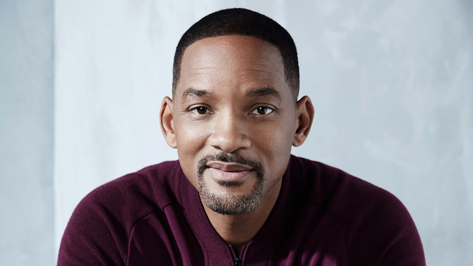 Will Smith at a public event, smiling for photographers with confident posture and polished styling