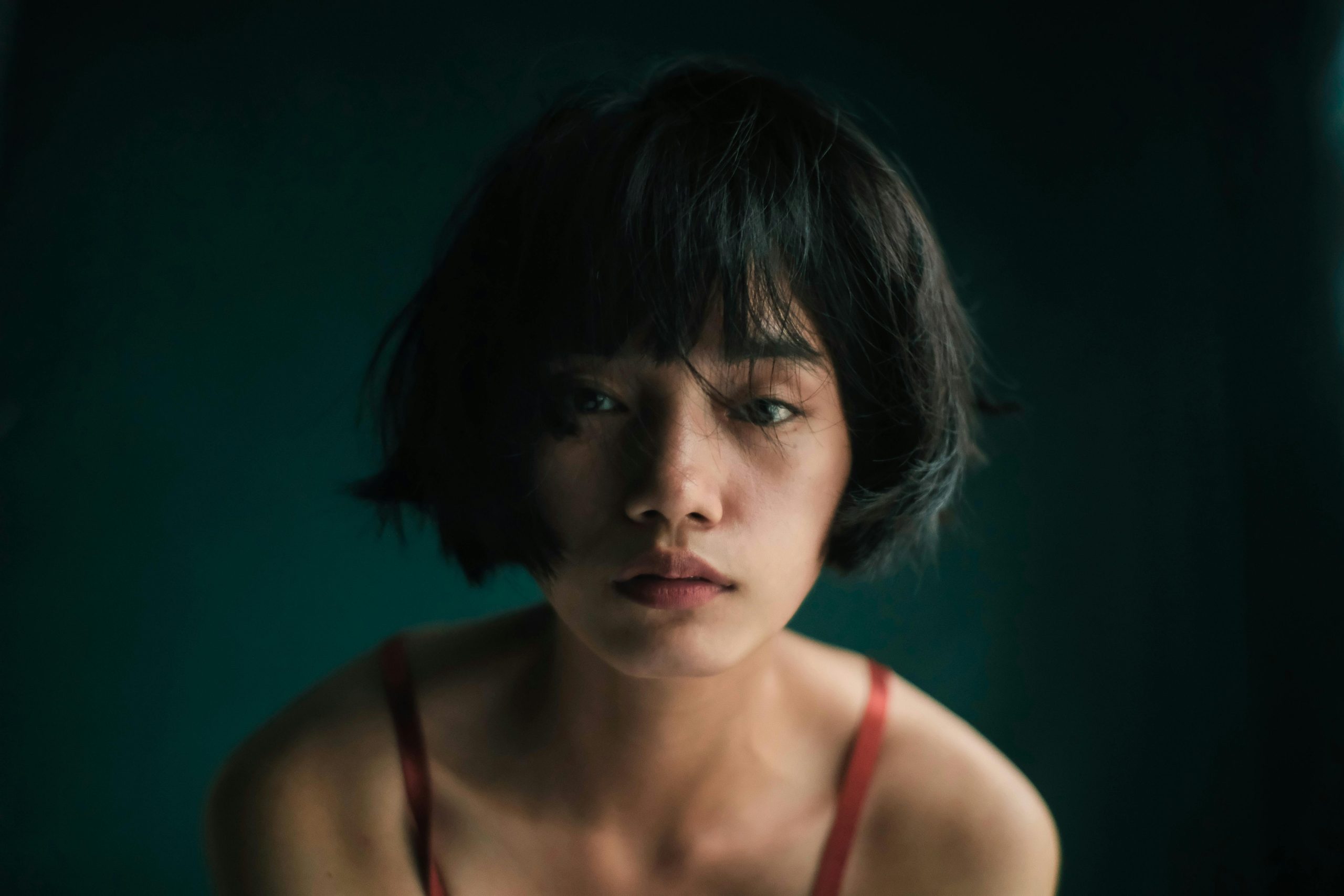 Woman with a sleek bob haircut that falls just below the chin, softly tucked under at the ends and parted to the side.