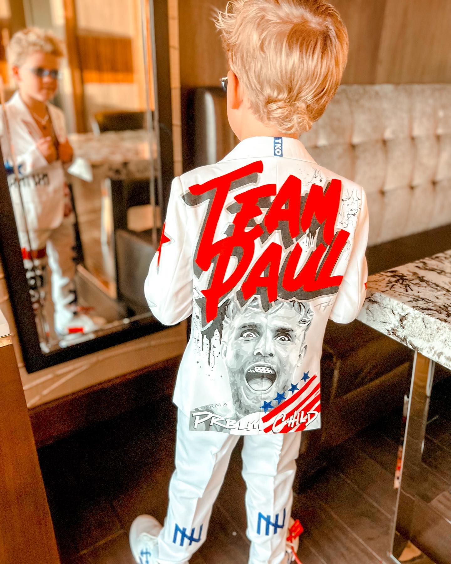 Young creator Tydus Talbott smiling with his family, representing a childhood spent in front of the camera and shaped by supportive parenting.