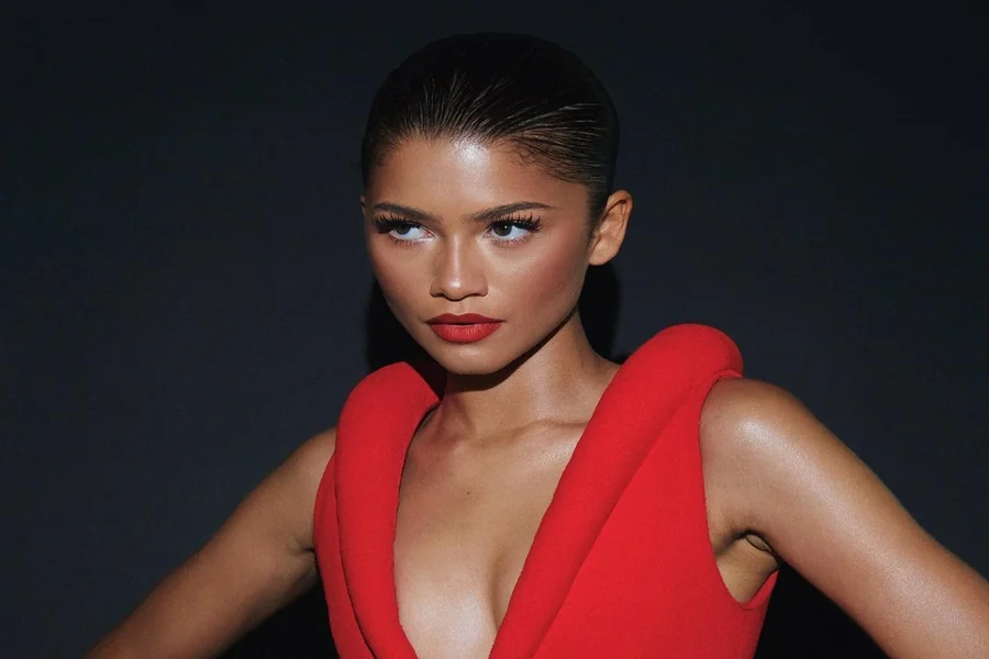 Zendaya standing confidently on a red carpet in high heels, highlighting her tall frame beside other Hollywood stars